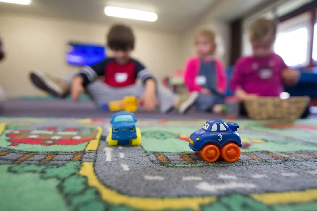 Children playing with toy cars on a play mat